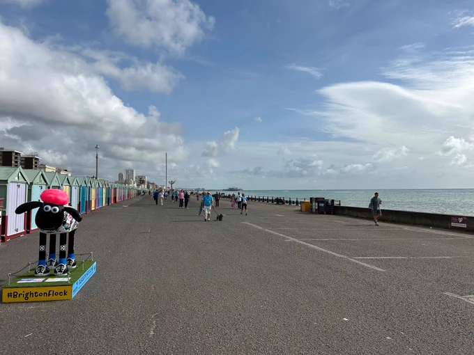 Shaun the Sheep sculpture on Hove promenade with sea and beach huts in the background