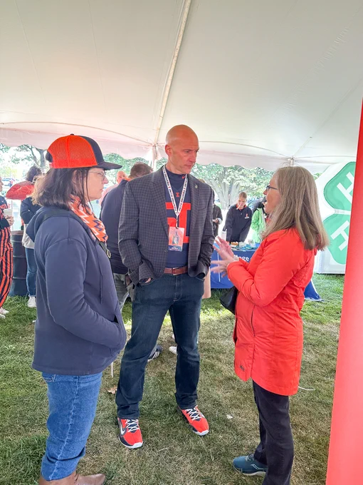 Josh Whitman talking with 2 individuals in the ACES tent at Celebrate Food and Ag