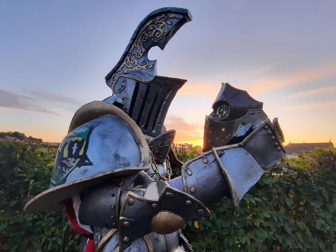 Photo of my lawbringer of cosplay looking at Apolyon's mask under a sunset , this is a cosplay of the vidéo game For Honor
