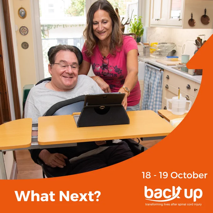 Image of a man with glasses smiling whilst looking at a tablet. There is a woman smiling stood next to him also looking at the tablet. there is an orange boarder along the bottom and righthand side of the graphic with white text that reads 18 -19 October. What next? Back up transforming lives after spinal cord injury.