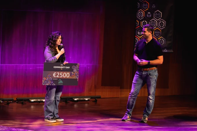 Photo on Martijn van Dongen and me on the stage of the AWS Community Day NL 2023, receiving a donation for SheSharp from the AWS community NL