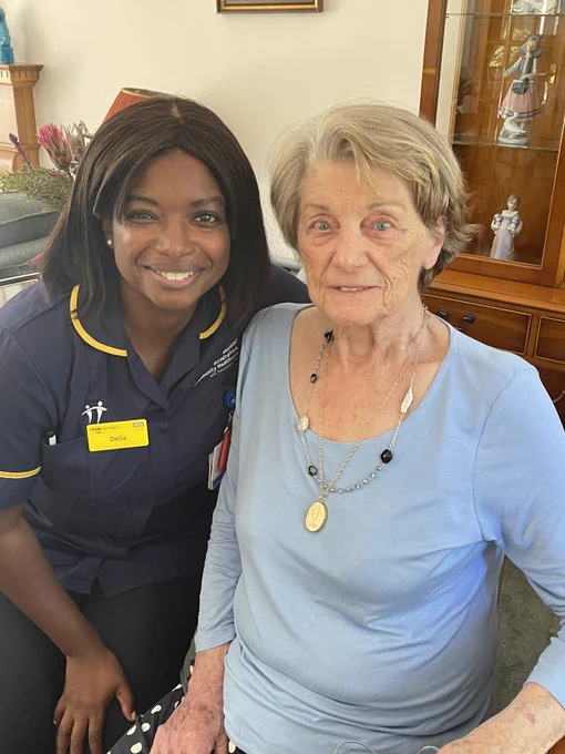 Della Thomas, a trainee Advanced Clinical Practitioner with the Respiratory Service from Birmingham Community Healthcare Trust, with Catherine. 

They are sat together and smiling, Della is on the left wearing a dark blue uniform with yellow piping and Catherine has a pale blue top on and is wearing two necklaces.