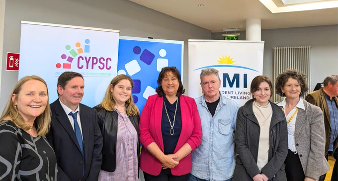 Image of 7 people. From left to right: Alice Griffin (DESSA), ____ (Department of Children, Equality, Disability, Integration and Youth), Bryony Trickey (Cobblestone Learning), Anne Rabbitte (TD, Minister of State), Peter Kearns (ILMI), Rachel McMahon (Cobblestone Learning), Nuala Ni Giobuin (CYPSC)