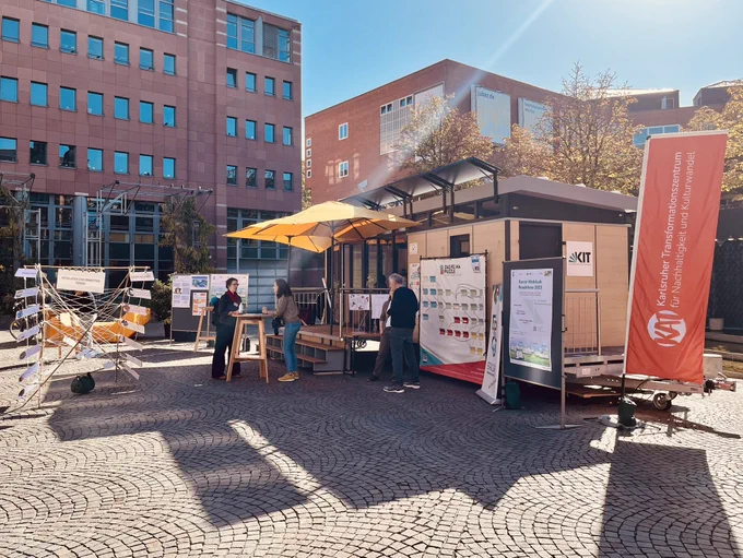 Das mobile Forschungslabor in Karlsruhe, davor stehen Pinnwände und Exponate.