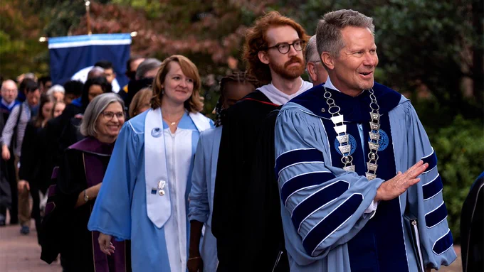 Chancellor Kevin Guskiewicz leading faculty and greeting students