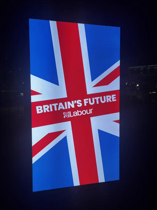 A digital board at the Labour Conference with the Union Jack and the Labour Party logo and the words Britain’s Future.