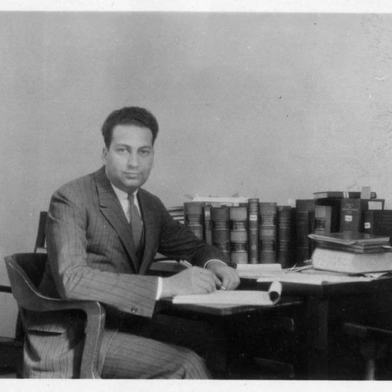 Detail, Paul Freund sitting at a desk in a room with law books and papers, taken while Freund was a student at Harvard Law School, 1931-1932. HOLLIS olvwork368799.