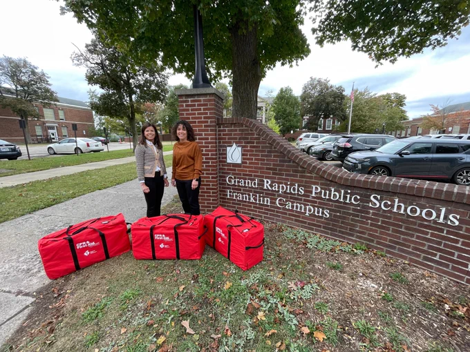 American Heart Association West Michigan Executive Director Jana Siminski, left, delivers three CPR Anywhere training kits to Kim Baron, Grand Rapids Public Schools, right, outside the district's administration building. 