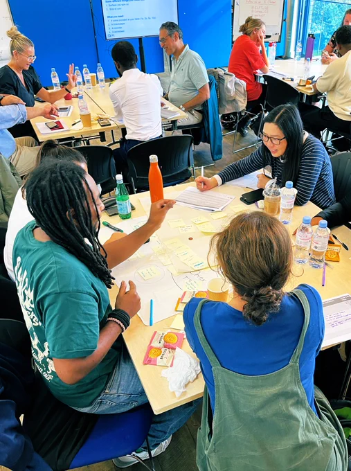A photo of a group of people on a training course spinning coins and looking very focused