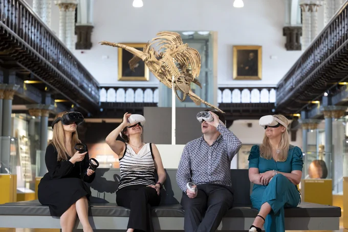 Four people wearing VR headsets sat looking up in a museum. 
Left to right: Dr Lynn Verschuren, Professor Maria Economou, Professor Neil McDonnell, Dr Pauline Mackay, who are part of the team working on the Museums in the Metaverse project at the University of Glasgow. They are photographed in The Hunterian at the University of Glasgow. Photo credit: Martin Shields
