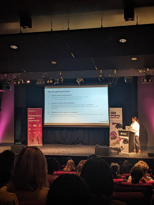 April on stage at Interact London - text on screen explained in tweet