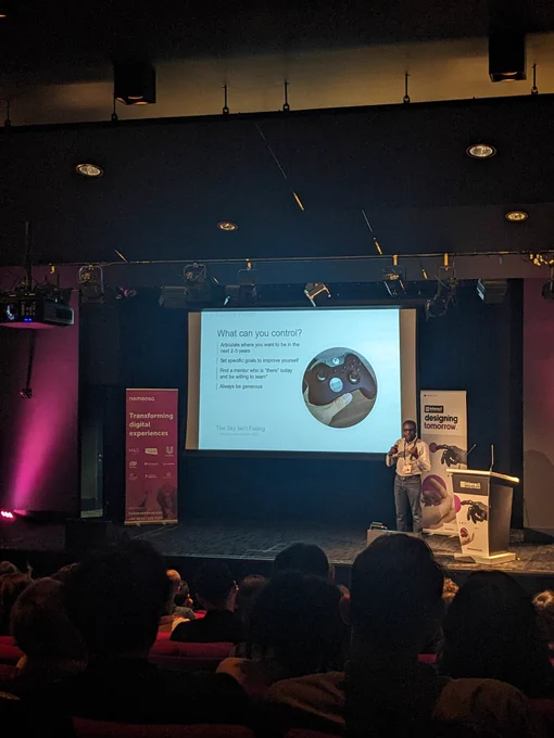 Kayode on stage at Interact London. Text on screen given in tweet