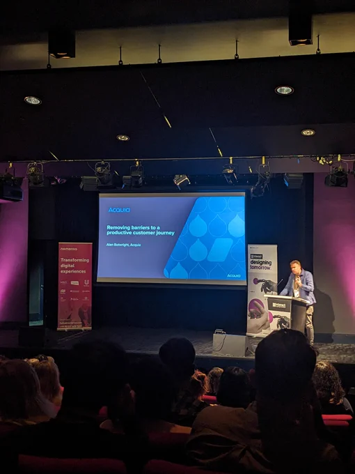 Alan on stage at Interact London. Text on screen given in tweet