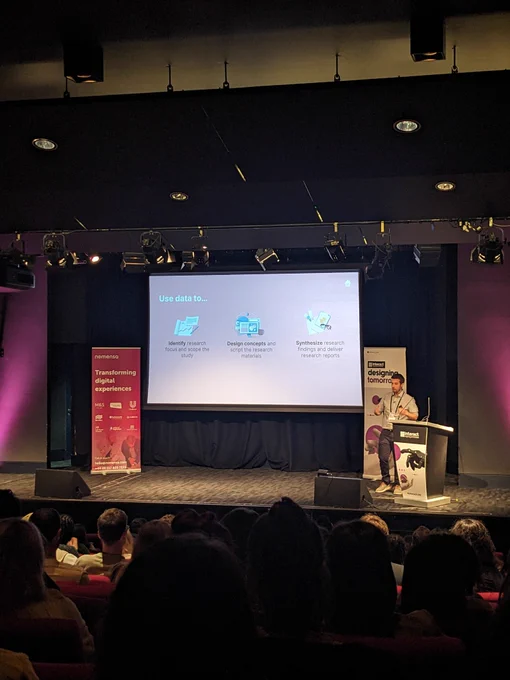 Doron on stage at Interact London. Text on screen given in tweet