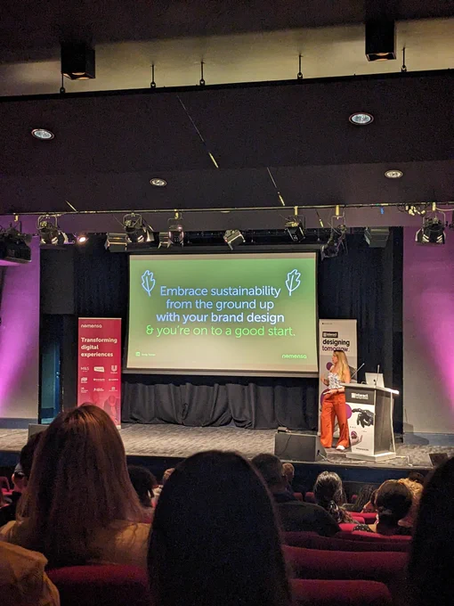 Emily on stage at Interact London - content on screen given in tweet