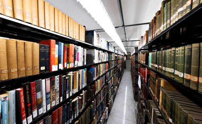 Library book stacks stretching into the distance. 