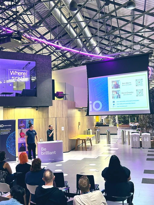 iO Associates speaking infront of a screen