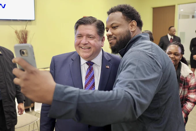 Governor Pritzker takes a selfie with a student.
