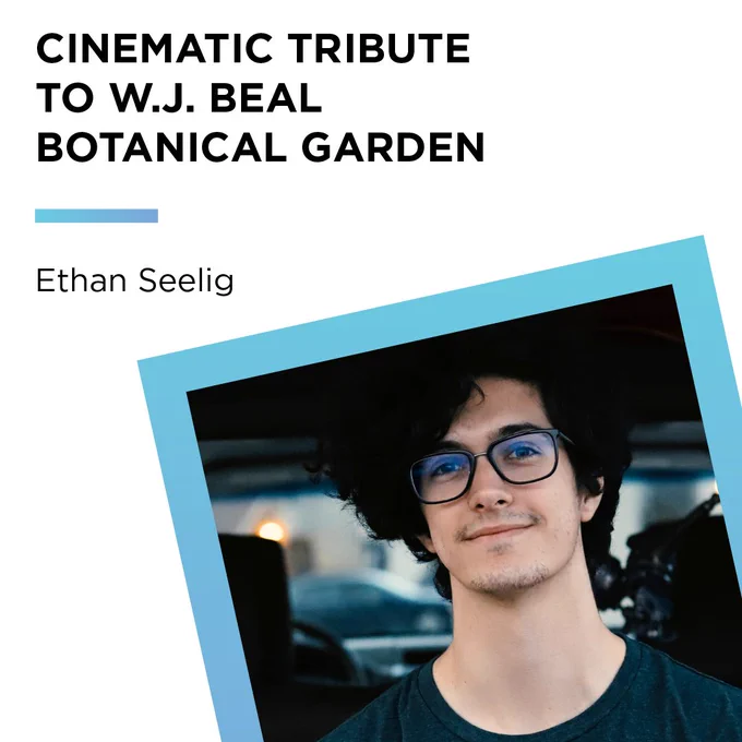 Ethan has short black curly hair, wear black glasses and a black shirt