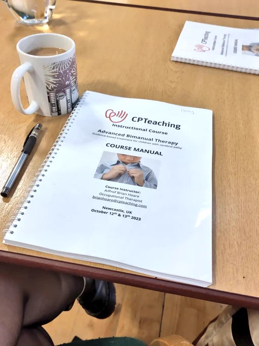 Table top with the course manual, pen and a cuppa