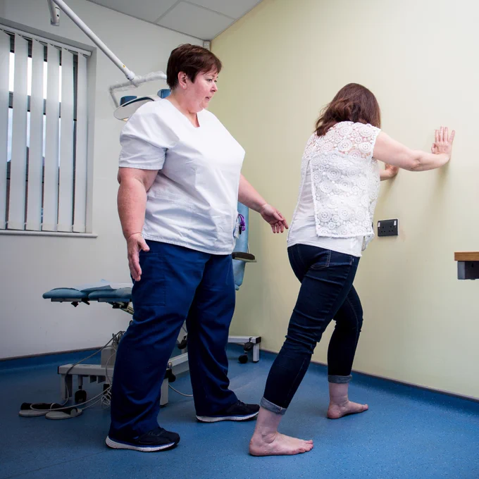 Podiatrist performing an exercise with a patient to treat a variety of issues.