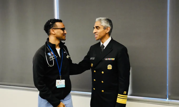 U.S. Surgeon General Vivek Murthy standing with a member of the Brigham and Women's Hospital community. 