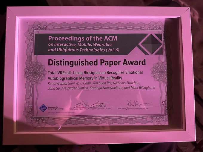 A framed award certificate in a white border with decorative elements. The title reads "Proceedings of the ACM on Interactive, Mobile, Wearable and Ubiquitous Technologies (Vol. 6)." Below it, the text states "Distinguished Paper Award" for the paper titled "Total VREcall: Using Biosignals to Recognize Emotional Autobiographical Memory in Virtual Reality." The authors listed are Kunal Gupta, Sam W. T. Chan, Yun Suen Pai, Nicholas Strachan, John Su, Alexander Sumich, Suranga Nanayakkara, and Mark Billinghurst. The Association for Computing Machinery (ACM) logo is present at the bottom left corner with signatures of the Editor-in-Chief and the Selection Committee Co-Chair at the bottom.

More Info: https://rb.gy/rv81k and https://doi.org/10.1145/3534615

