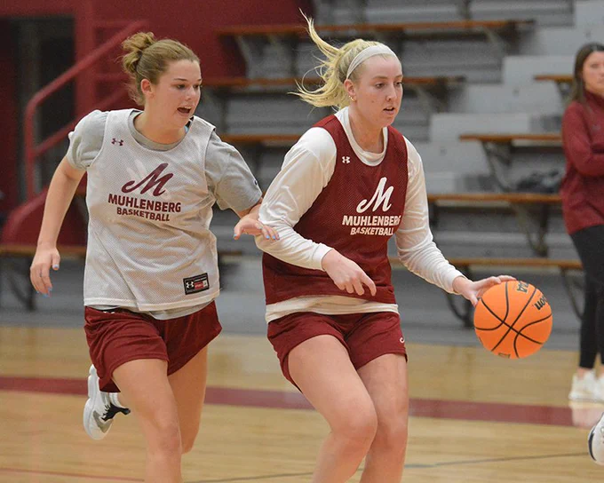 women's basketball player in red jersey dribbling