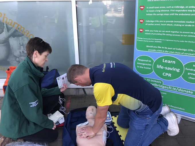 A Celbridge CFR volunteer teaches a member of the public to do chest compressions and use an AED on a mannequin