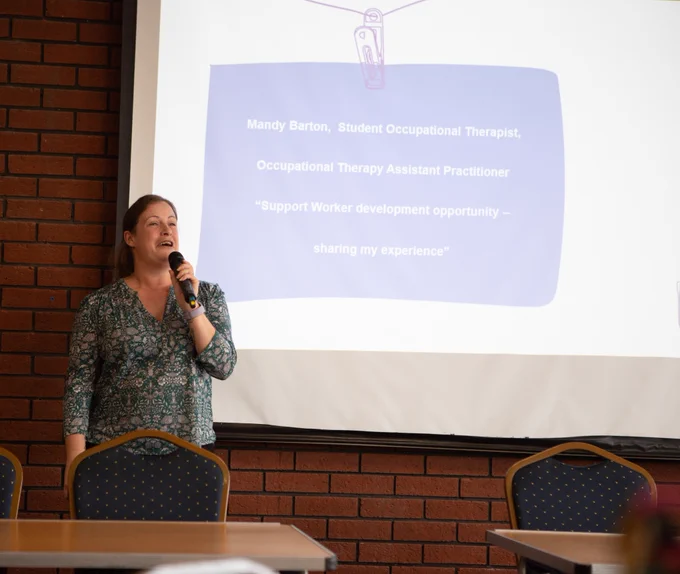 Mandy speaking at the ahp event with microphone in hand