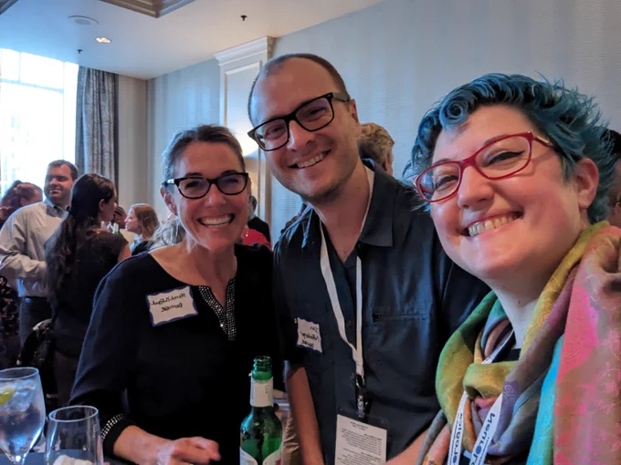 Three people at a cocktail party, 2 attendings and a resident, all smiling and having a great time networking.
