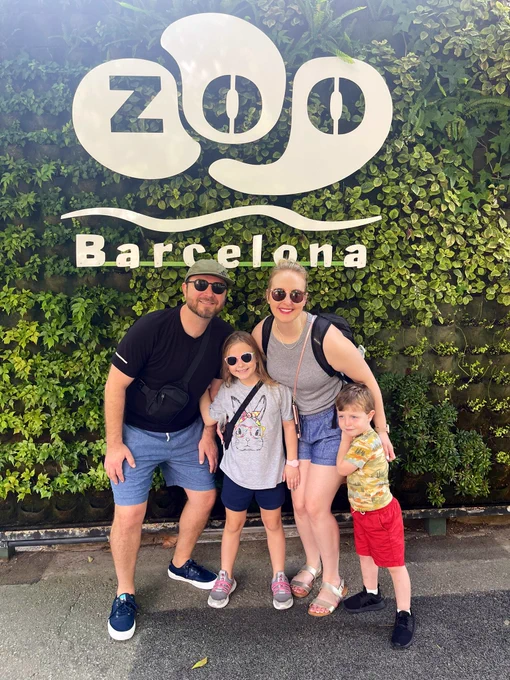 Barcelona Zoo sign with the family posing in front.