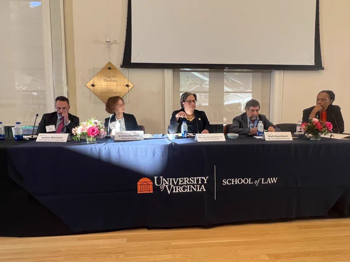 From left to right: Joshua Weishart, Kristine Bowman, Rep. McClellan, Mark Rosenbaum, and Kimberly Jenkins Robinson sit at a long table for a panel discussion. There is a navy blue table cover with white text that reads "University of Virginia School of Law." 