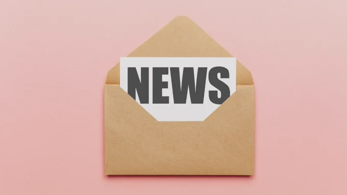 Auf dem Bild ist ein Briefumschlag zu sehen. Aus dem Umschlag heraus schaut ein Zettel auf dem News steht.