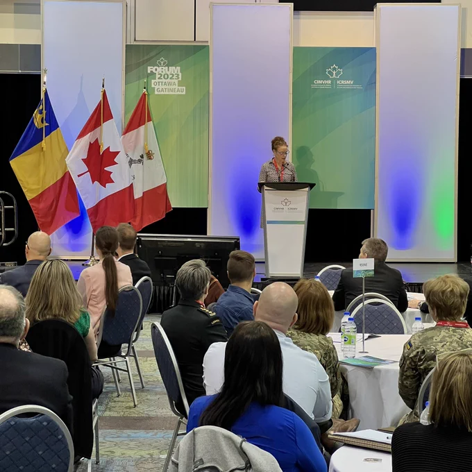 Dr. Margaret Bourdeaux speaks at a podium to attendees.