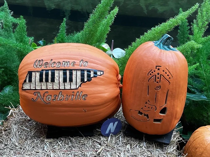 Two pumpkins. One is carved with a piano in the shape of Tennesee and reads: Welcome to Nashville! and the other is a boot.