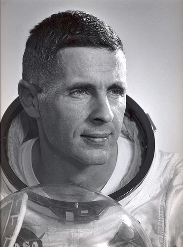 1968 portrait of astronaut William A. Anders wearing a spacesuit and holding the helmet.
