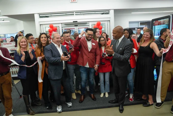 Mayor claps after cutting ribbon right in front of entrance inside new target store alongside several other city officials and store employees