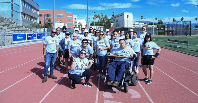 People smiling and posing on a race track.