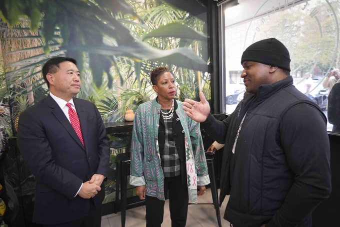 Speaker Adams and Commissioner Kim speaking with a small business owner 