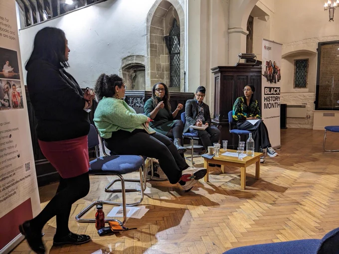 Colour photograph of 5 panel speakers talking.
