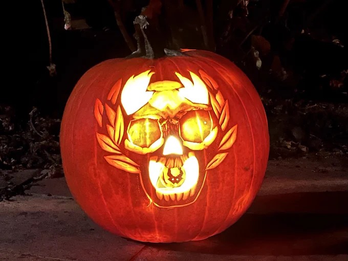 It's a jack-o-lantern carved with the skull from the Hades game, gems for eyes, a crown of laurels, and a coin in its mouth for Charon