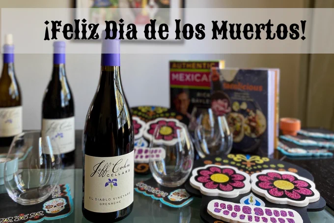 A Dia de los Muertos themed table set with bottles of Jeff Cohn Cellars Grenache and Mexican cookbooks.