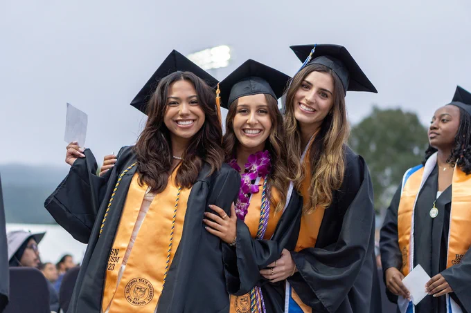3 CSUSM Grads posing and smiling