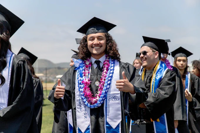 CSUSM Grad smiling and giving thumbs up