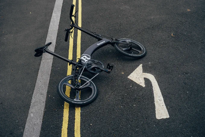 Hummingbird Bikes and Rouleur collaboration bike lay on the road next to a left turn road marking