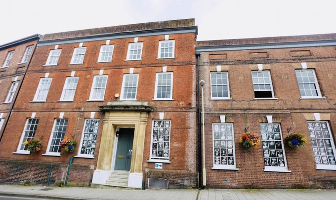 A picture of Exeter Community Centre. A  3 storey period building, with a green door.