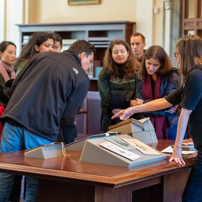 Tour leader KB Beck shares materials from Historical & Special Collections with tour guests.