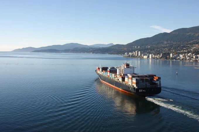 Photo d'un bateau transportant des conteneurs maritimes qui quitte le port de Vancouver.