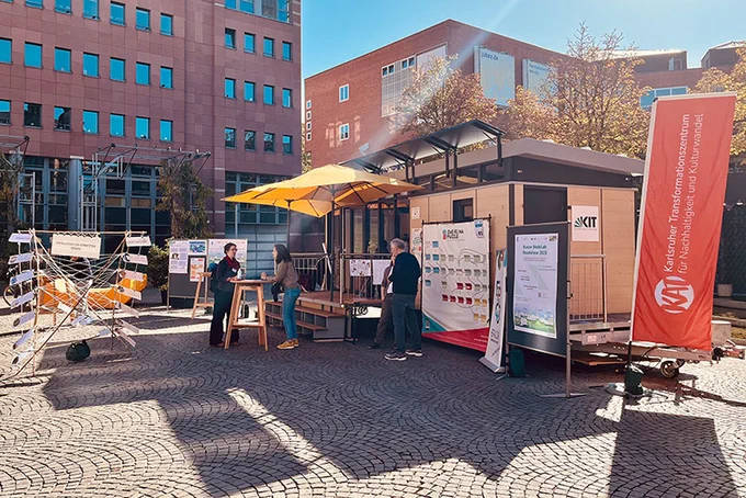 Das mobile Forschungslabor MobiLab bei der Science Week 2023 in Karlsruhe. Menschen stehen davor.  